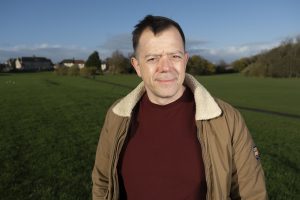 Gareth standing in a park with blue sky behind him