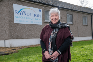 Linda stands in front of Rays of Hope building 