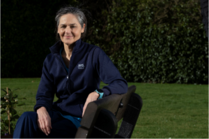 Woman sat on a bench smiling