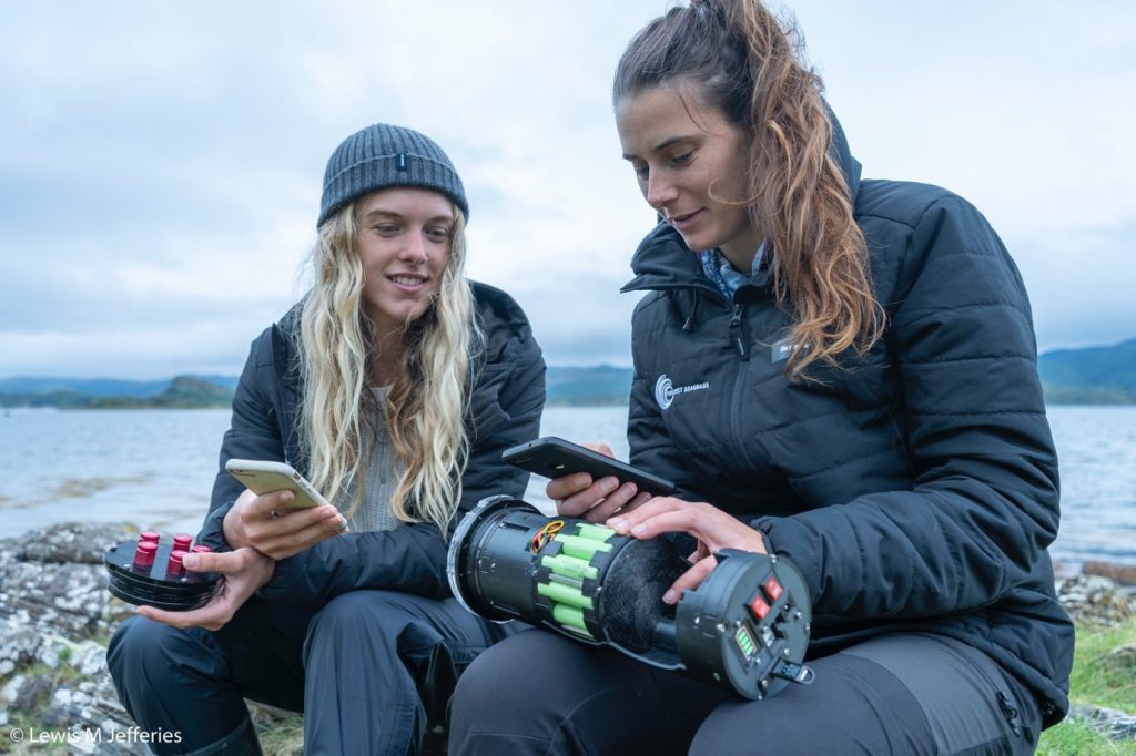 Two people looking at and working with innovative technology devices to capture biodiversity data associated with Scottish seagrass ecosystems. Copyright: Lewis M Jefferies