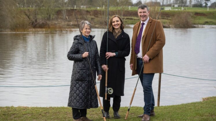 L-R Duchess of Sutherland, Màiri McAllan and Jamie Stewart, Chief Executive of the River Tweed Commission, standing in front of the river Tweed holding fishing rods