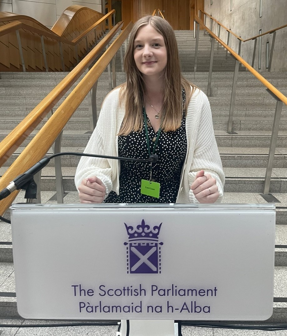 Ellie Craig MSYP standing at a podium in Scottish Parliament