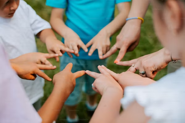 children standing in a circle with their fingers outstretched completing the circle