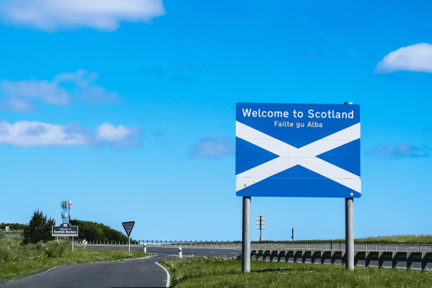 Photo of a Welcome to Scotland road sign on a sunny day